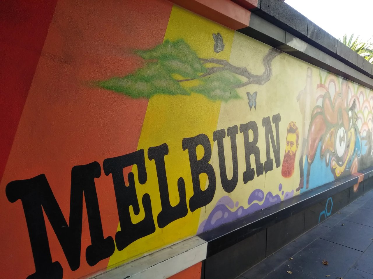 Bunte Graffiti-Wand in Melbourne mit "Melburn" Schriftzug.