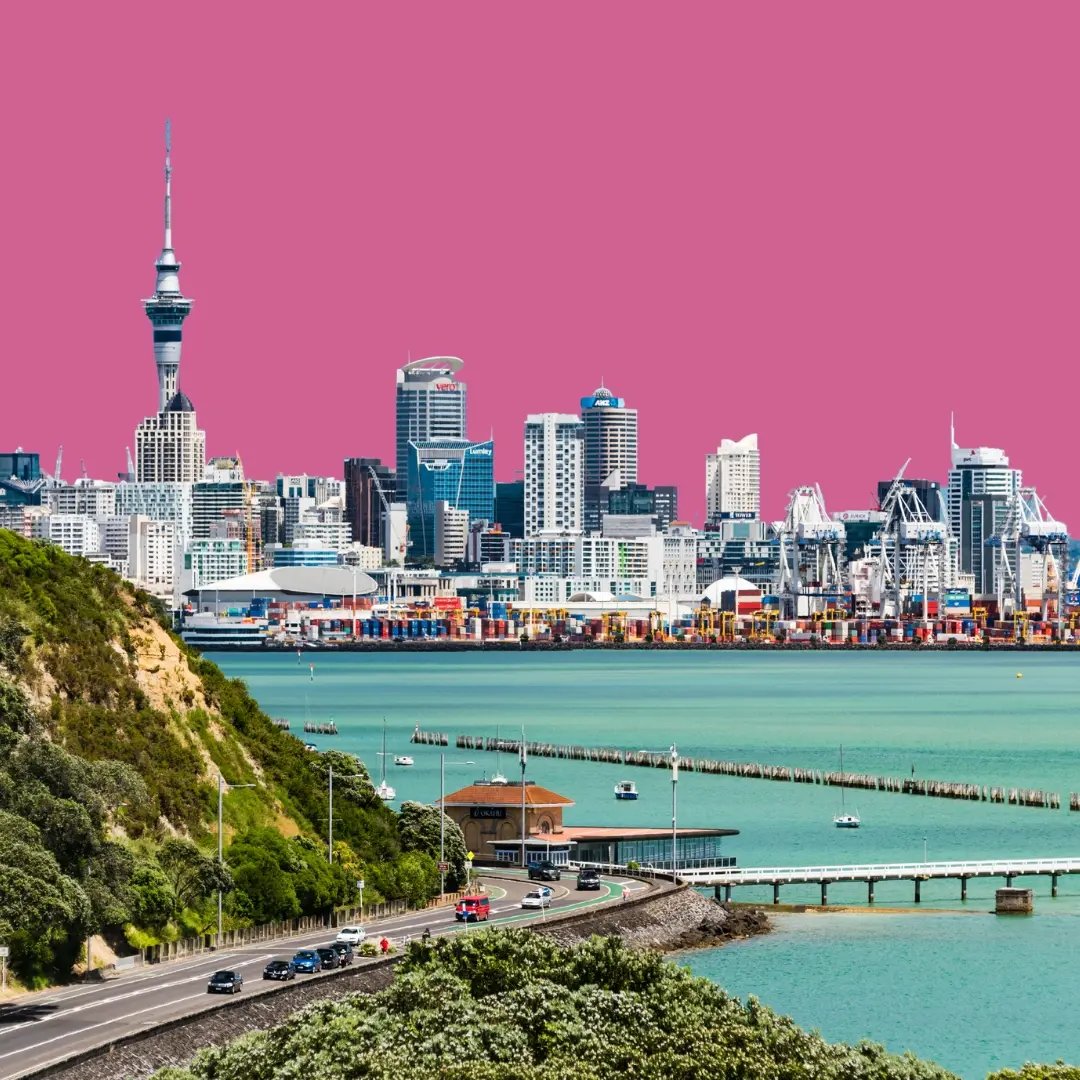 Blick auf die Skyline von Auckland und einen Hügel vom Wasser aus vor pinkem Hintergrund