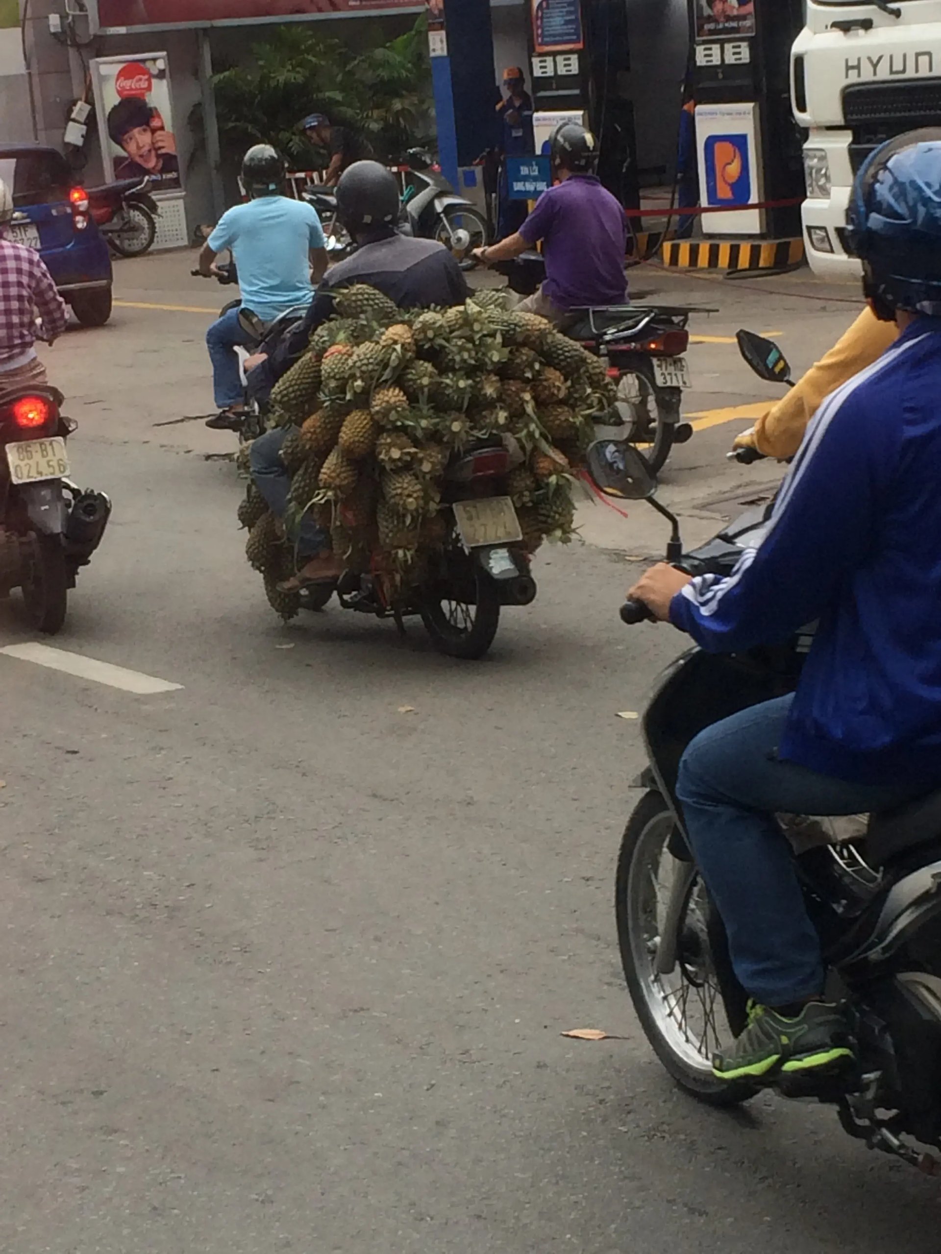 Ein voll beladenes Motorrad mit frischen Ananas fährt durch die Straßen von Vietnam.