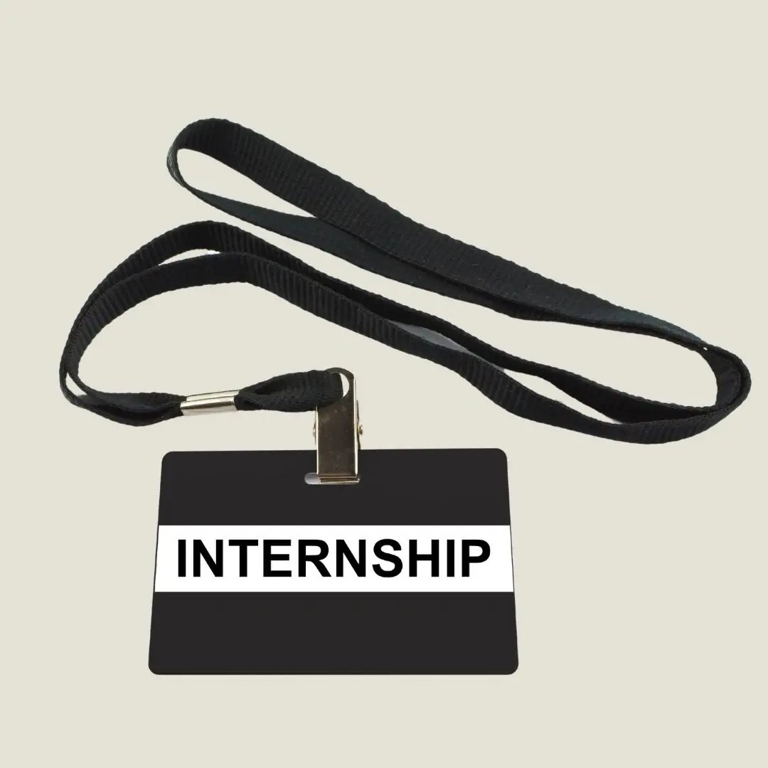 Schwarzes Namensschild mit der Aufschrift "INTERNSHIP" an einem schwarzen Lanyard – Symbol für Praktikum und berufliche Erfahrung.