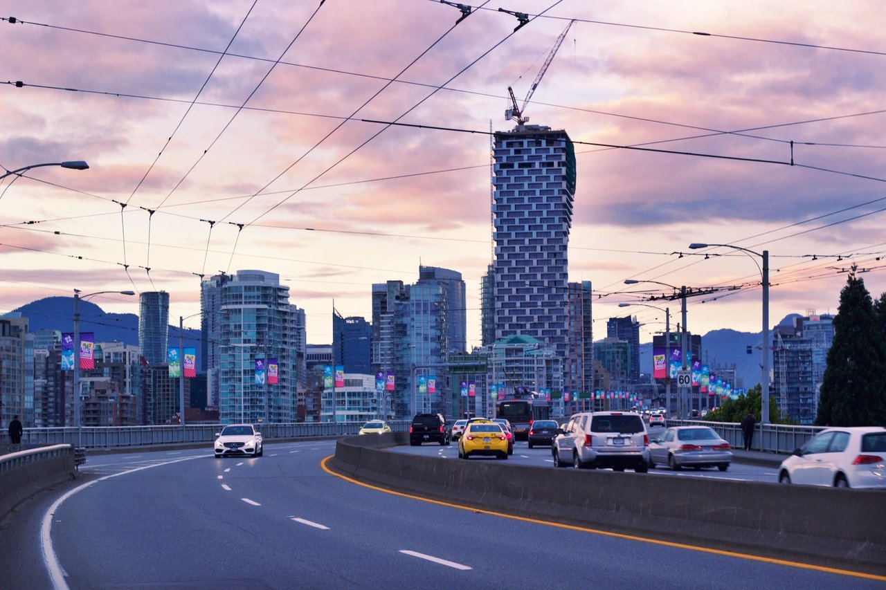 Abendliche Skyline von Victoria mit Brücke und Stadtverkehr.