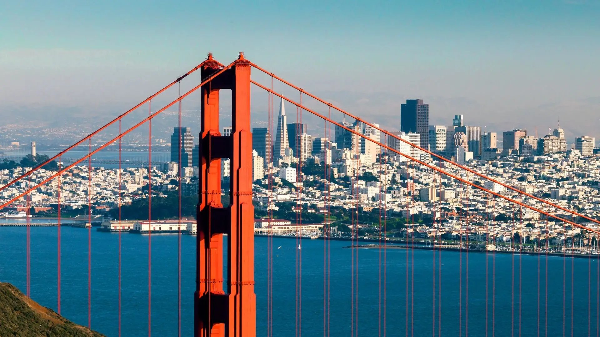 Die Golden Gate Bridge in San Francisco mit der Skyline der Stadt im Hintergrund an einem klaren Tag.
