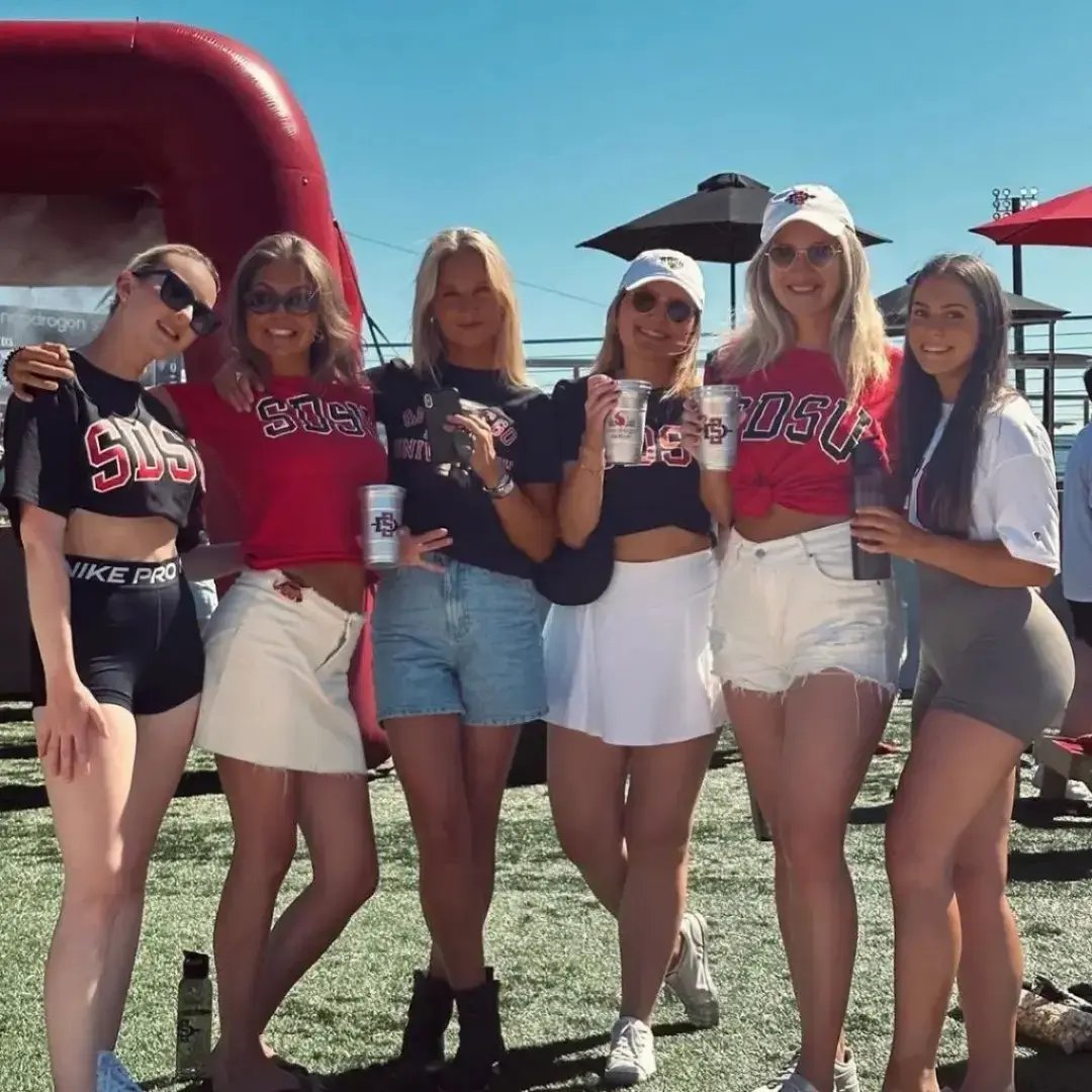 Gruppe von sechs Studentinnen in San Diego State University Kleidung posiert bei einer Outdoor-Veranstaltung.